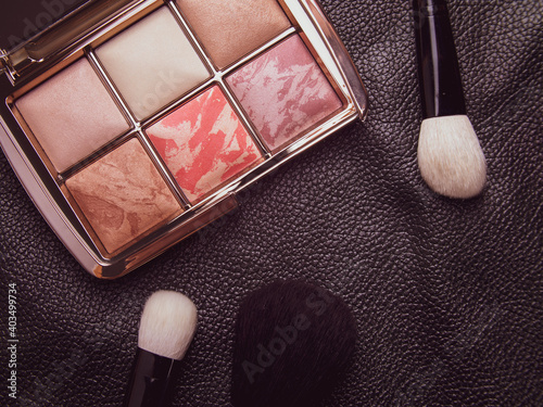 premium cosmetics on a black background. brushes, mascara and powder