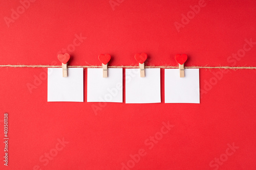 I love you concept. Close up flat lay view photo of pins with small hearts holding four cards with letters love isolated bright color red background photo