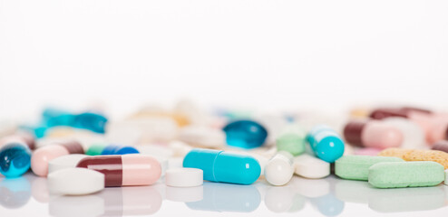 Banner panoramic horizontal close up view photo image of different shape and color pile heap of capsules lying on white desk