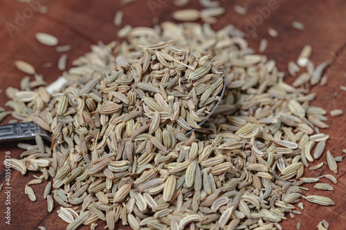 fennel seeds in spoon on wooden table