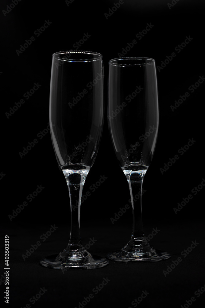 Two empty champagne flutes in a black background Two empty champagne flutes in a black background