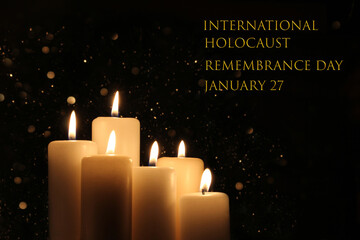 International Holocaust Remembrance Day January 27. Burning six white candles with lights glow on black background.