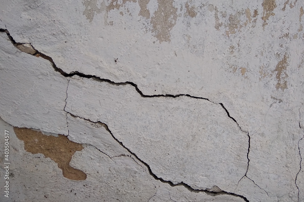 Obraz premium Grunge texture of an old concrete wall with peeling plaster and cracks. City view, old cracked wall.