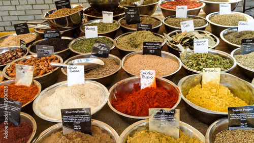 A colorful table full of bowls of bulk spices available for purchase at a farmer's market