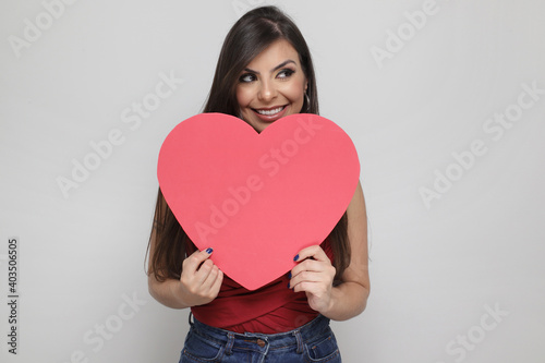 beautiful girl holding valentine's gift on white background