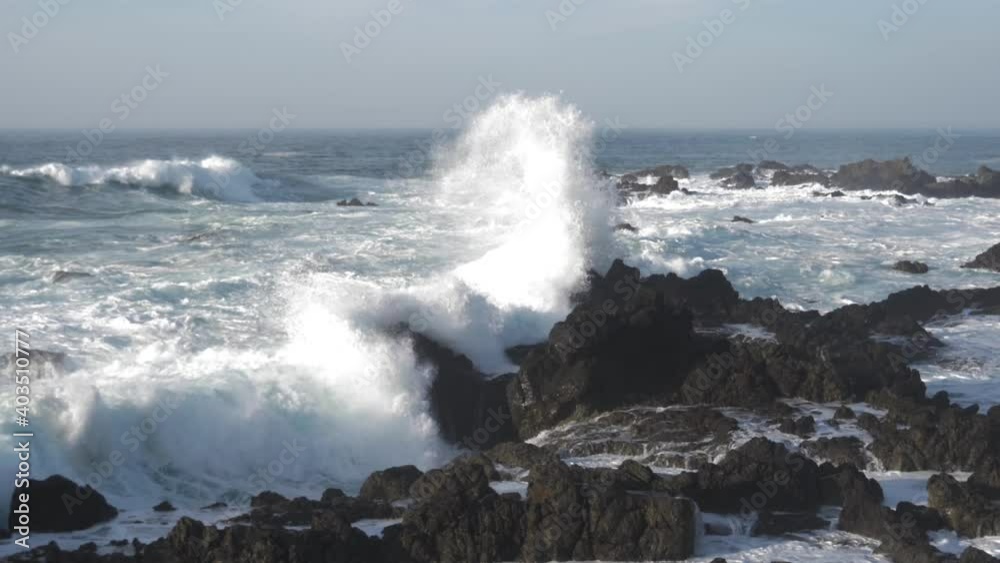 Rocky beach landscape with huge waves crashing into coast slow motion