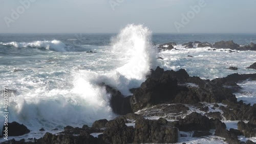 Rocky beach landscape with huge waves crashing into coast slow motion