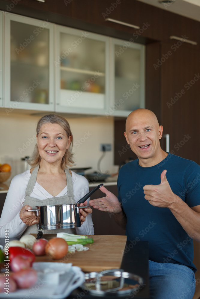 A man and a woman are sitting at a table in the kitchen and are going to cook. A man and a woman are sitting at a table in the kitchen and are going to cook.