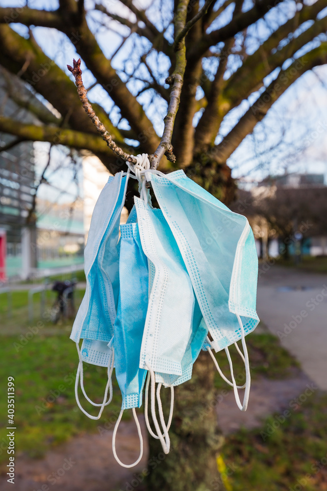 used covid masks hanging from a tree used covid masks hanging from a tree