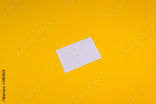 White envelope on orange background. Top view. Copy space