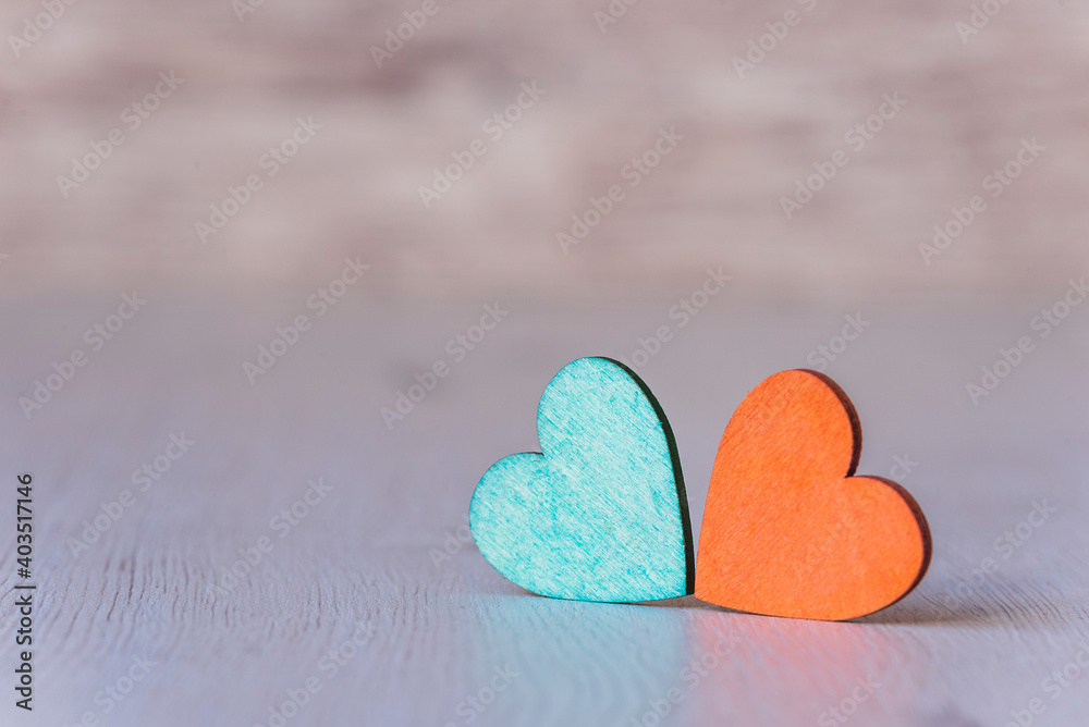 Background with two green and orange hearts, on wooden background Background with two green and orange hearts, on wooden background