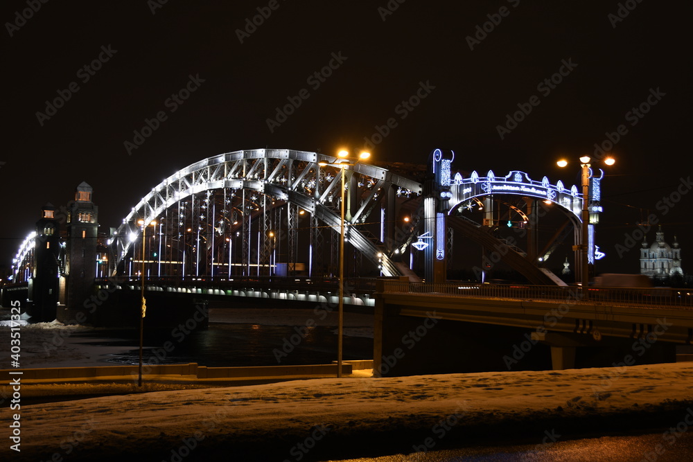 Obraz premium Illuminated bridge across the river in winter