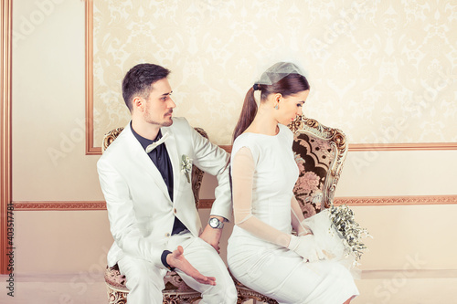 Fotografia Angry young bride and groom upset on each others sitting in armchairs