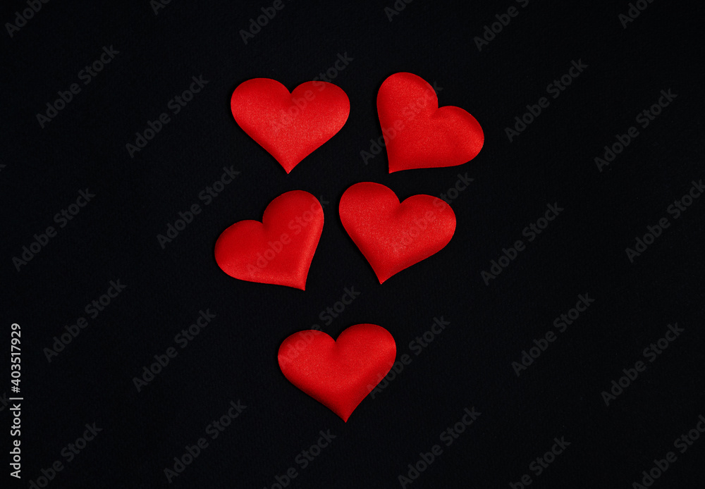 Top view of red hearts spread on a black background. Border, copy space, celebration, holiday.