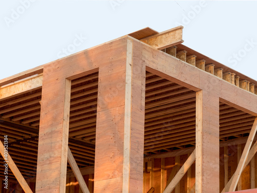 corner walls of a house under construction showing plywood sheathing and engineered wood floor joists for a second story