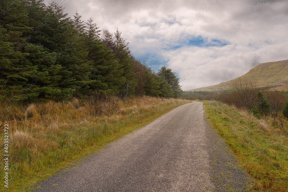 Small narrow road by a forest by a mountains. Gleniff horseshoe drive, county Sligo, Ireland, Cloudy sky, Travel concept. Nature landscape.