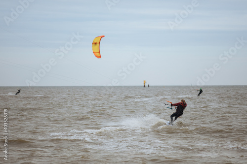 Girl kitesurfing on the North Sea in a black wetsuit