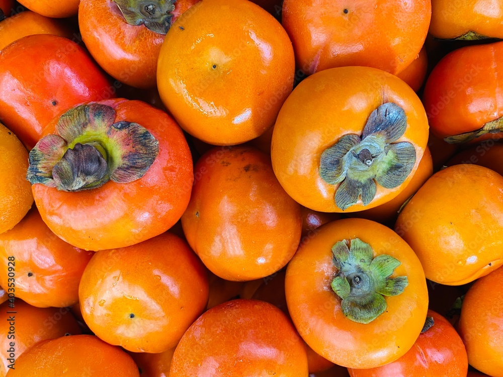 Close-up photo of Persimmons in market. Group of fruits background. Close-up photo of Persimmons in market. Group of fruits background.