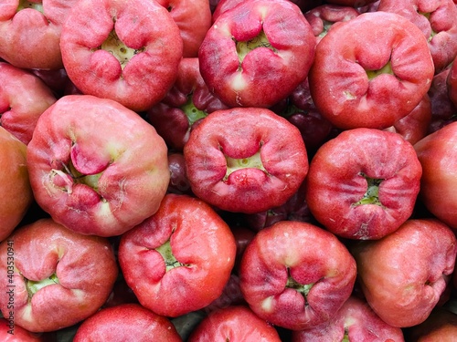 Close-up photo of Wax-apples (Syzygium samarangense) in market. Group of red fruits background.  photo