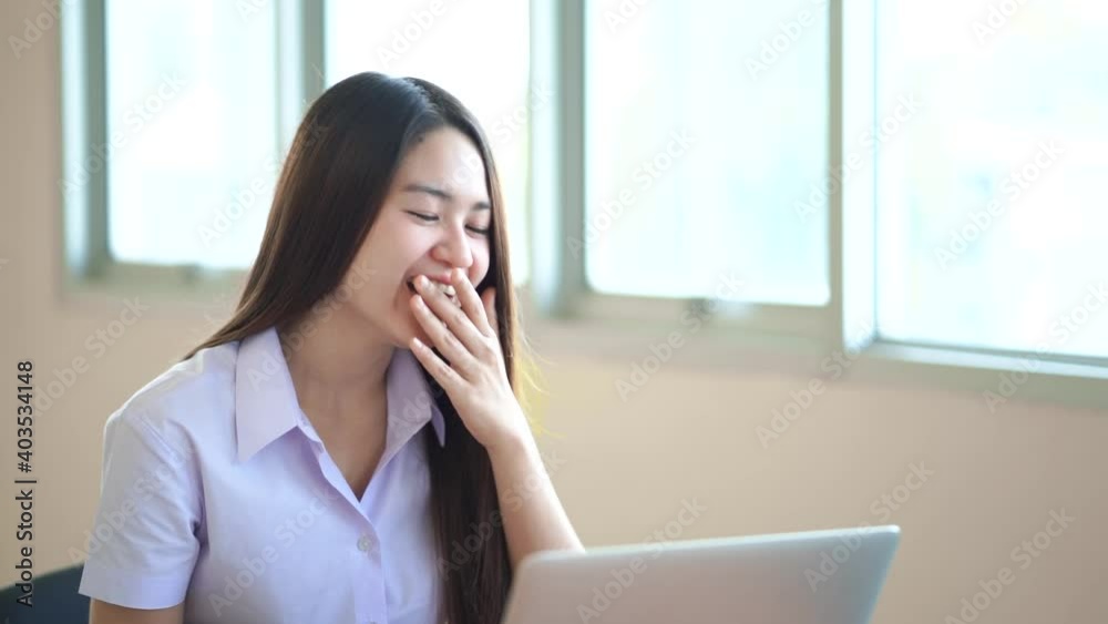 The beautiful student sat and laughed happily. At the desk there are laptops and notebooks on the table. The beautiful student sat and laughed happily. At the desk there are laptops and notebooks on the table.
