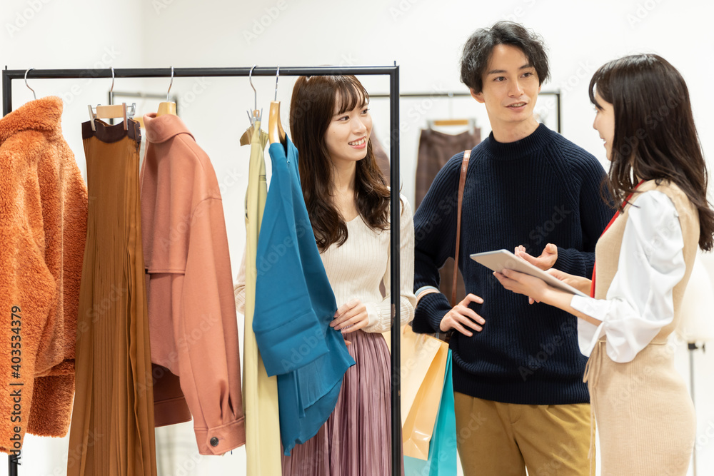ショッピングをするカップルと店員 ショッピングをするカップルと店員