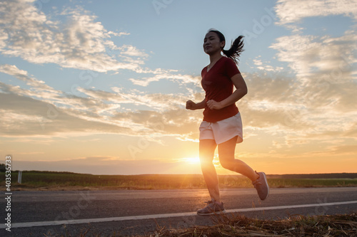young fitness woman runner running on sunrise road, Exercise concept.