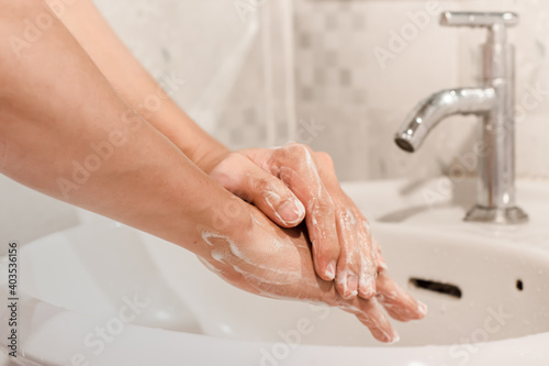 Close-up of man washing his hands in the bathroom. Hygiene concept for prevention COVID - 19.