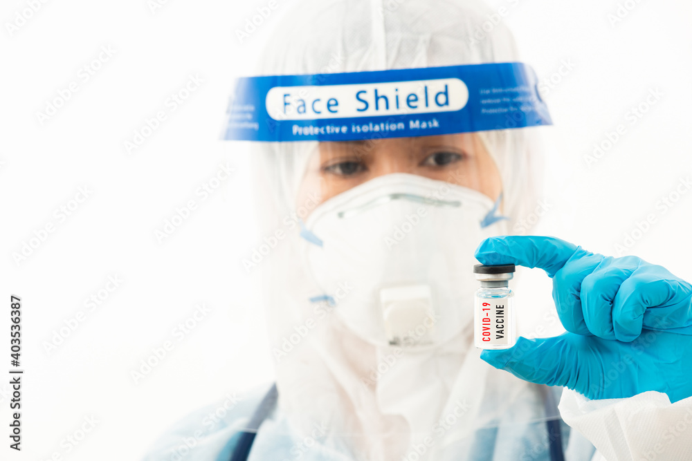 Closeup female medical scientist in PPE uniform wearing a face mask protective and plastic face shield holding Coronavirus (COVID-19) vaccine on hand isolated on white background Closeup female medical scientist in PPE uniform wearing a face mask protective and plastic face shield holding Coronavirus (COVID-19) vaccine on hand isolated on white background