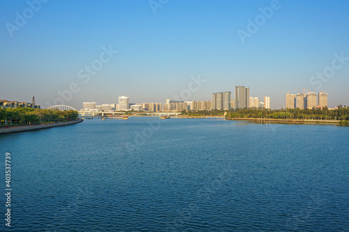 Landscapes of Xiamen Wuyuanwan Natural Park and Wuyuan Bridge in distance with water foreground and Xiamen city skyline