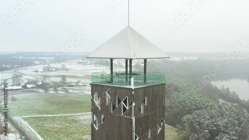 Aerial view of tall and empty birstonas tower in winter time. Orbiting while snowing photo