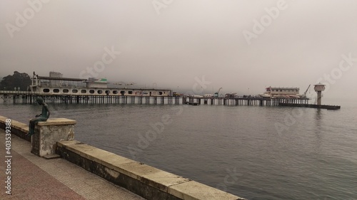 Seaside promenade with a view of the old pier washed by the rain