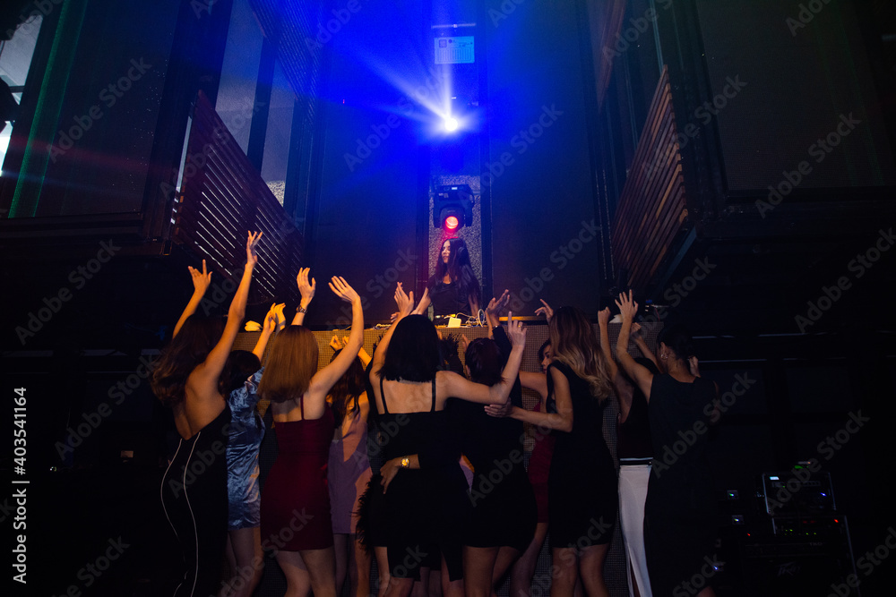 Fototapeta premium Group people women dancing in night party with DJ EDM Music