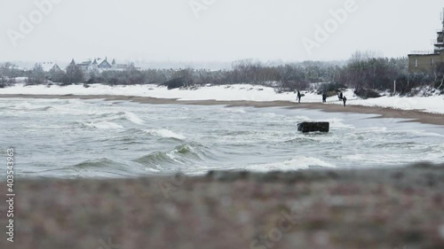 Snowy beach with people. Slide shot. photo