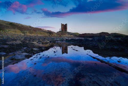 Sunrise with water reflections at seafield tower, fife, scotland.