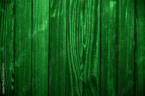 Close-up old green wooden fence with copy space. A wall of frayed wooden planks. Texture of old painted boards. Texture of old wooden planks with peeling paint. Background and texture for design