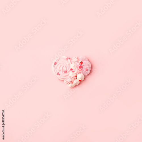Pink merengue candy heart shape on pink background, monochrome minimal concept, sign of love, Saint Valentine day greeting card, flyer, invitation, banner, promotion abstract