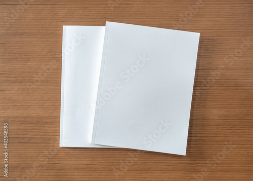 Book mockup with blank white front cover page a4 paperback mock up for catalog, magazine, menu, booklet, notebook, portfolio design template on wood table background