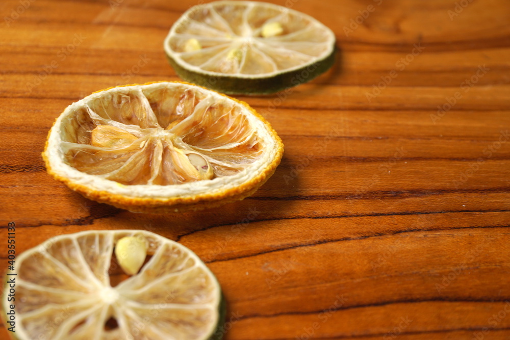 Grainy dried-slice lemon and lime in wooden textured background Grainy dried-slice lemon and lime in wooden textured background