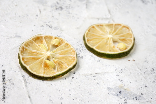 Grainy dried-slice lemon and lime in wooden textured background