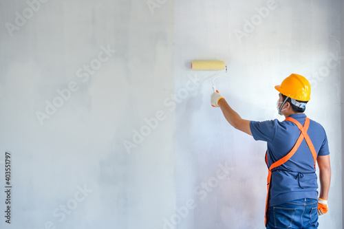 Fototapeta Naklejka Na Ścianę i Meble -  Young Asian painters have The joy of painting interior white walls with paint roller in new house.