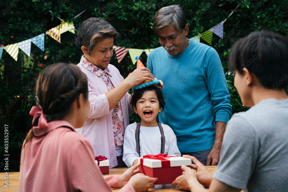 Fototapeta premium Asian family celebrate kid birthday party together outdoor at yard.
