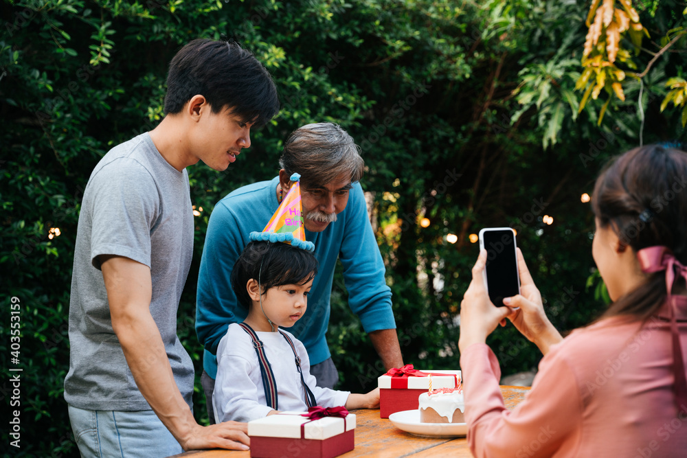 Asian family celebrate kid birthday party together outdoor at yard. Asian family celebrate kid birthday party together outdoor at yard.