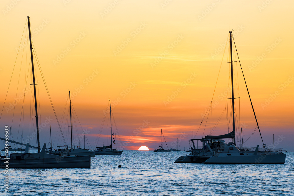 Sailing boats at Vesteys beach at sunset in Darwin, Australia.