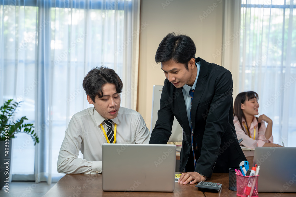 Asian business staff group present and working together,Kindly supervisor train new staff in office. Asian business staff group present and working together,Kindly supervisor train new staff in office.