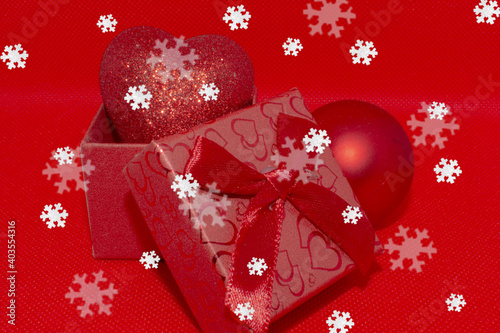 Valentine's day, gift in a red box with a heart on a background of snowflakes photo