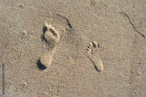 Natural background of sand with the prints of human feet