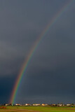 Huge rainbow over the Tuscan countryside against a dark cloudy sky