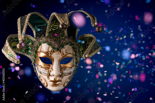 Venetian carnival mask among flying confetti