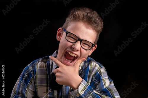 Child with glasses and shirt laughing sympathetically in camera photo