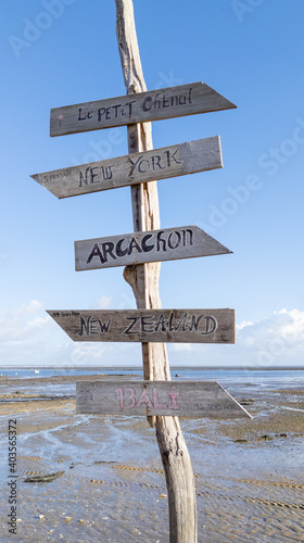 wood beach post with different wooden signboards pointing to various destinations in arcachon bay France